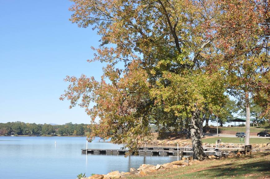 Trees in fall foliage next to Lake Bowen. A boat ramp juts into the lake.