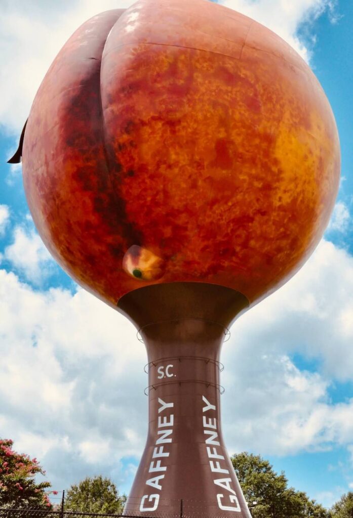 A water tower shaped as a peach. The bottom of the tower says Gaffney vertically in white against brown paint.