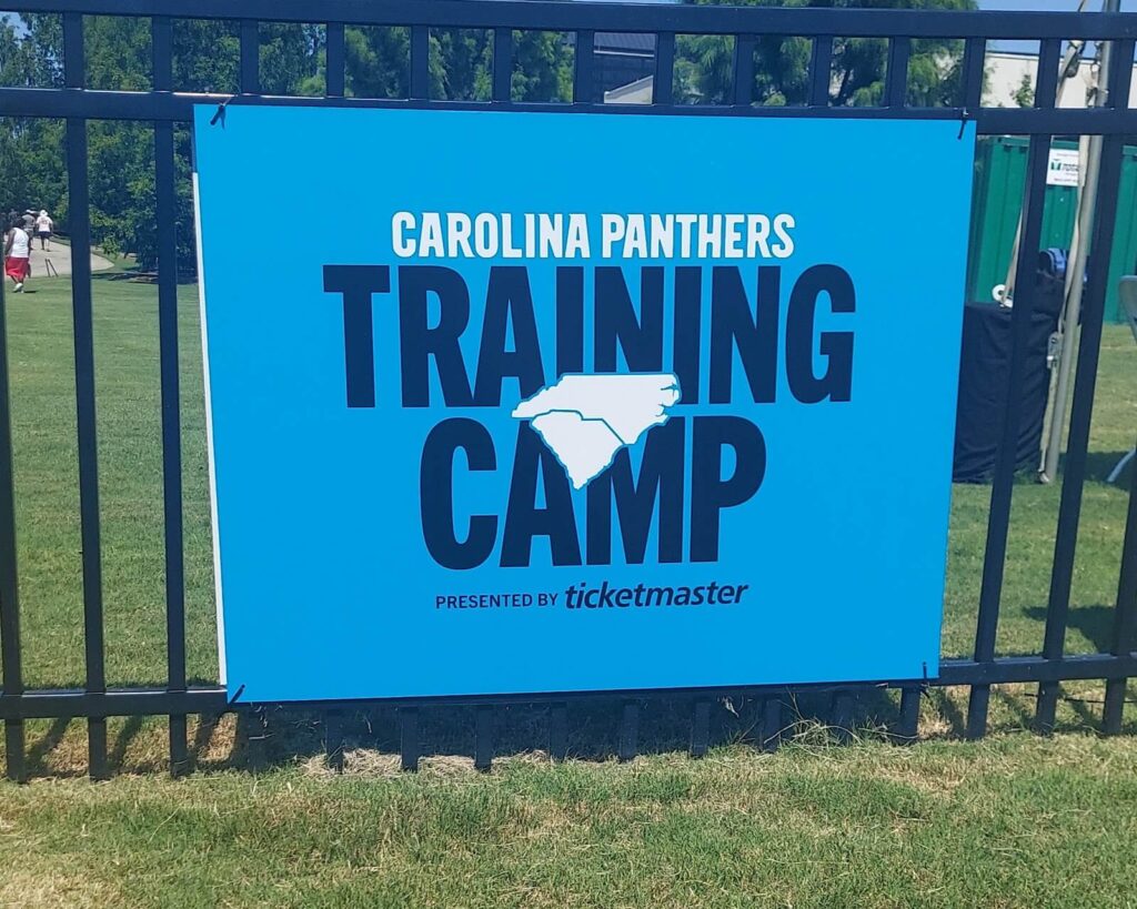 A sign that says Carolina Panthers Training Camp presented by Ticketmaster.